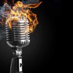 Vintage microphone engulfed in flames and smoke.