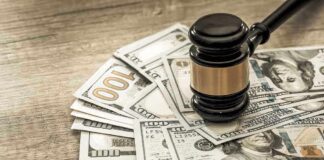 Gavel on a pile of hundred-dollar bills.