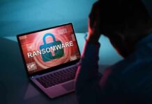 Person distressed over ransomware screen on laptop.