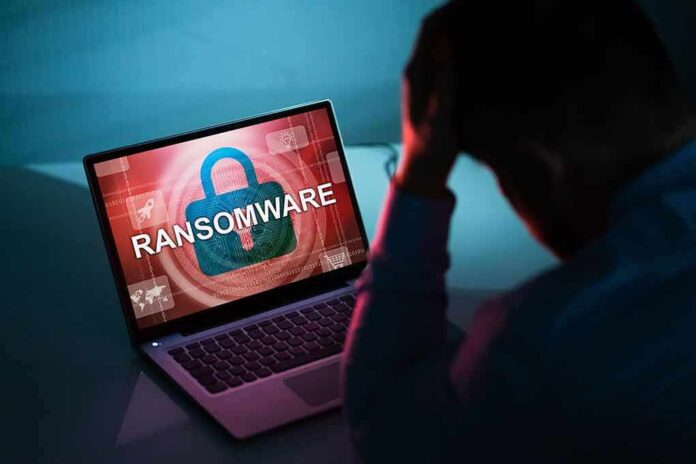 Person distressed over ransomware screen on laptop.