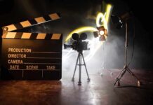 Film set with clapperboard, camera, and lighting.