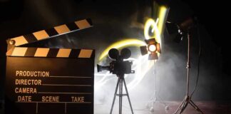 Film set with clapperboard, camera, and lighting.