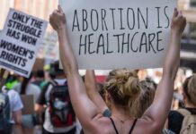 Protestors holding signs about women's rights and healthcare.