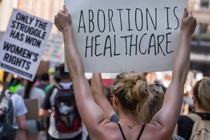 Protestors holding signs about women's rights and healthcare.