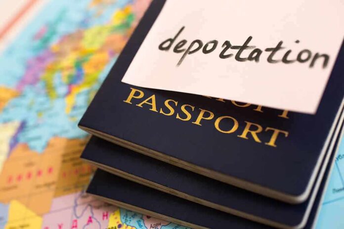 pile of passports with the word deportation written on a sticky note attached to top