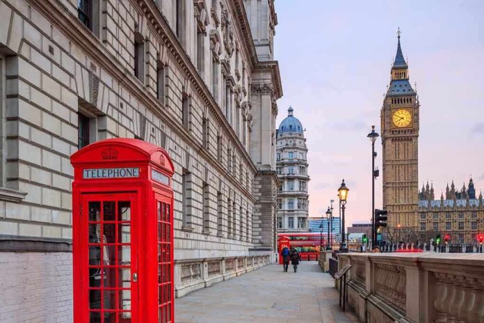 Red telephone booth near Big Ben in London.