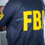 FBI agent searching shelf in office.