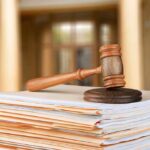 China’s Major Pharma Scandal: Top Executives Face Consequences Gavel resting on stack of paperwork in courtroom.