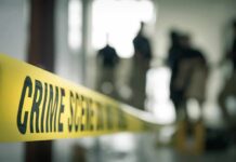 Yellow crime scene tape with people in background.