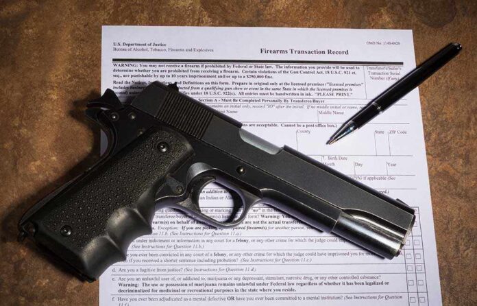 1026045637 featured image Gun and pen on firearm transaction form.