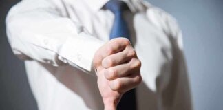 Person giving a thumbs down gesture.
