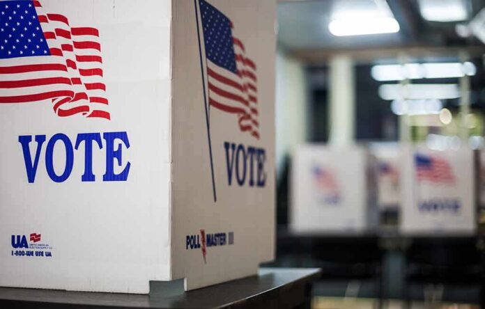 1837302940 featured image Voting booths with American flags and "Vote" signs.