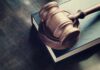 Wooden gavel resting on thick book
