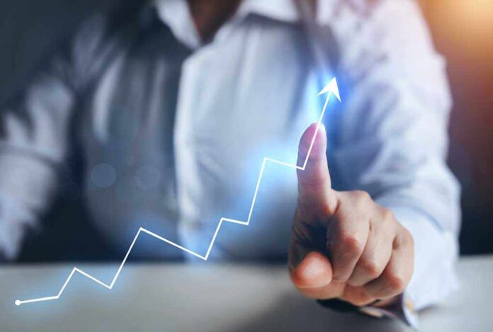 1936001935 featured image Person pointing at an upward trend line graph.
