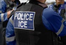 Police officer wearing vest with ICE label
