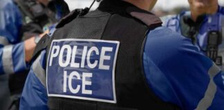 Police officer wearing vest with ICE label