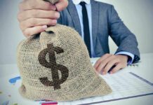 Person holding burlap sack with dollar sign.