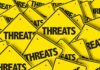 Yellow warning signs with the word THREATS