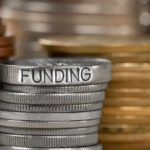 Stack of coins labeled funding with other coins stacks