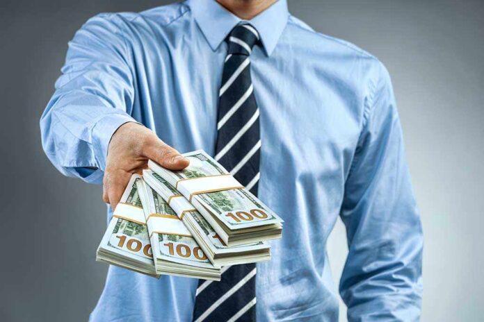 1008204853 featured image Person handing over a stack of money