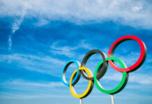 Olympic rings against a bright blue sky backdrop