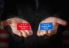 Hands holding Republican and Democratic Party cards