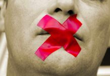 Man with red tape over mouth for hate speech