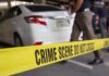 Crime scene tape blocking off white patrol car