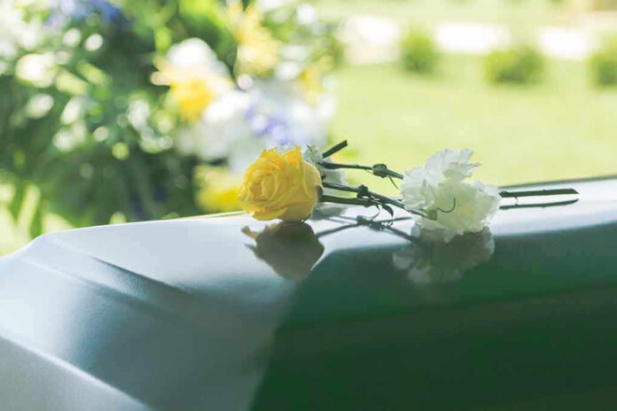 1014454810 Flowers on a closed casket at a funeral