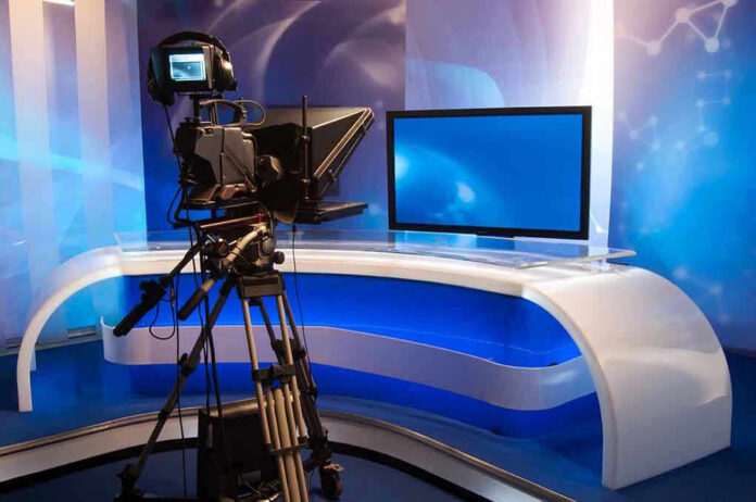 115378765 TV studio with camera and empty anchor desk