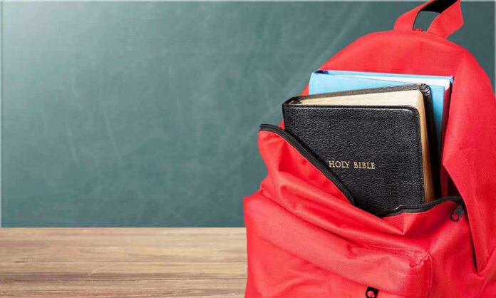 1183389583 Red backpack with a Bible and books inside