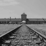 Railroad tracks leading to historical brick building gateway