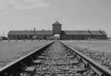 Railroad tracks leading to historical brick building gateway