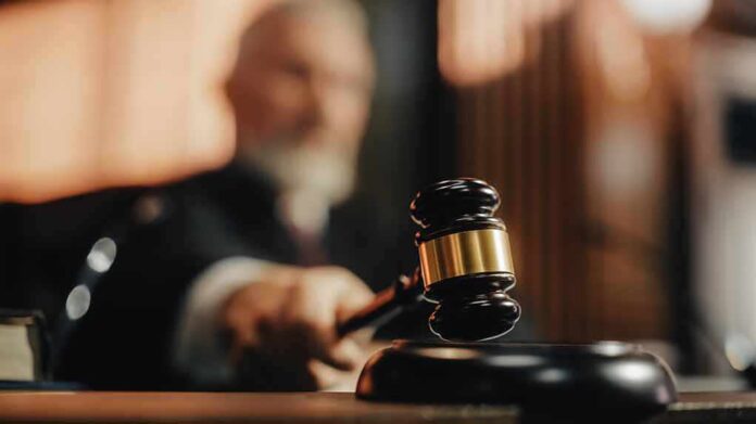2056414424 featured image Judge using gavel in a courtroom setting.