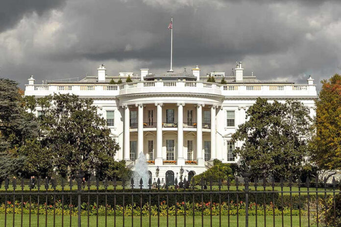 560339335 The White House with overcast sky and flag raised