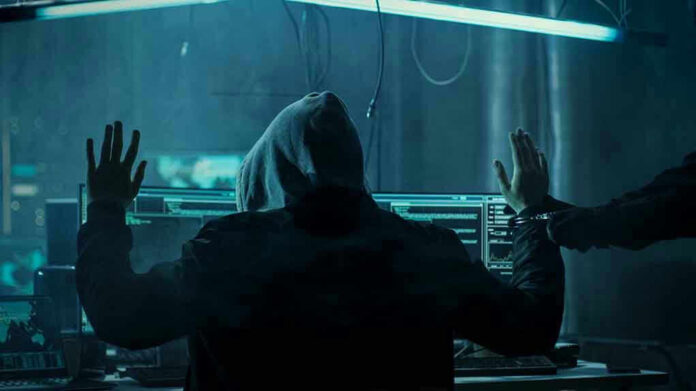 680075263 Hacker in hoodie arrested at computer desk