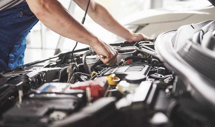 759448675 Mechanic working on an engine in a car