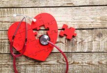 STUNNING Discovery Links Heart To Brain Decline Red heart puzzle with stethoscope on wooden background.