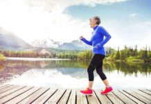 Fitness Rulebook SHATTERED by 30-Second Walks Senior woman jogging along a lakeside with mountains in the background