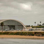 Taliban Negotiations STUN Pentagon — Demands Airfield Back! Aircraft hangar with helicopters near the beach.