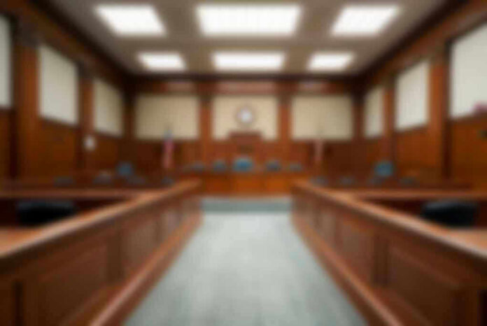 Empty courthouse courtroom with wooden benches and chairs.