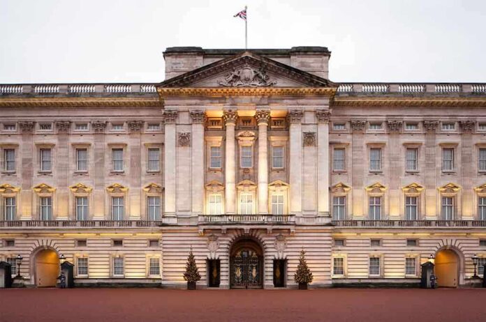 Front view of Buckingham Palace with illuminated facade and British flag