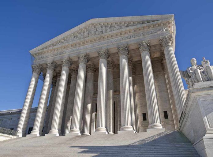 The Supreme Court building featuring grand columns and statues under a clear blue sky