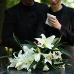 SYTYKD Shocking Death – Tragic Final Moments! Mourners in black holding white flowers at funeral.