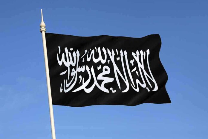 Black flag featuring Arabic script against a blue sky