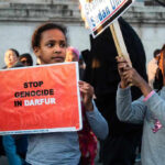 Children holding signs at a protest against Darfur genocide.