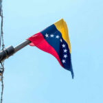 Venezuelan flag flying on a pole.