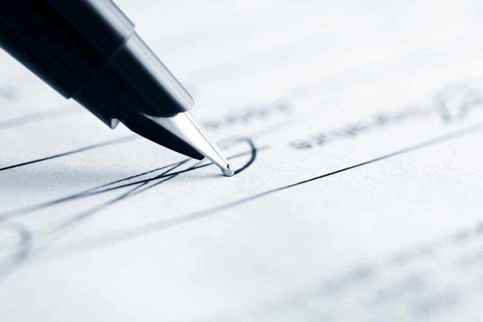 shutterstock_107661059.jpg Close-up of a pen poised above a document with handwritten lines