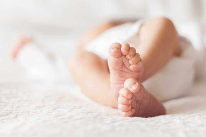 Close-up of baby feet lying on blanket.