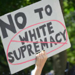 Sign saying No to white supremacy with red circle.